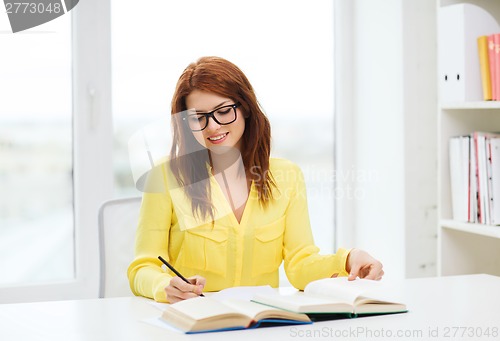 Image of smiling student girl reading books in library