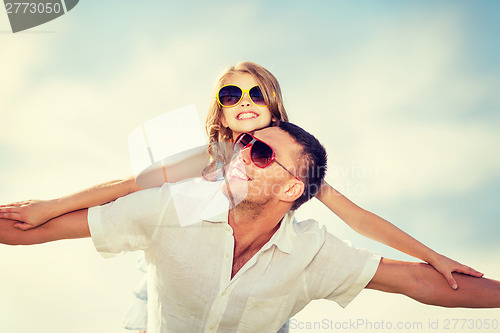 Image of happy father and child in sunglasses over blue sky