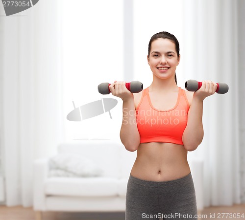 Image of young sporty woman with light dumbbells