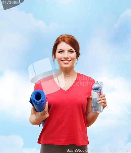 Image of smiling girl with bottle of water after exercising