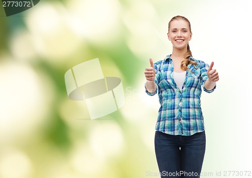 Image of young woman in casual clothes showing thumbs up