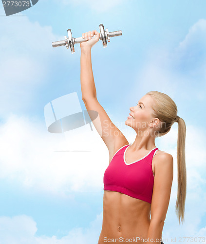 Image of smiling woman with heavy steel dumbbell