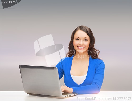 Image of smiling woman in blue clothes with laptop computer
