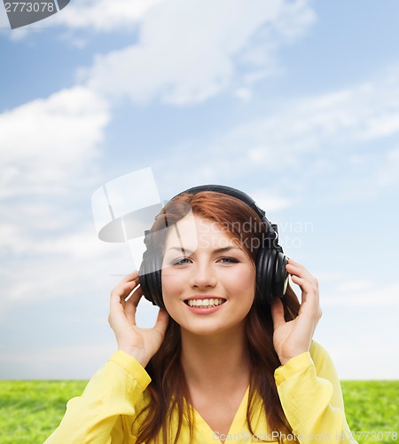 Image of smiling young girl in headphones at home