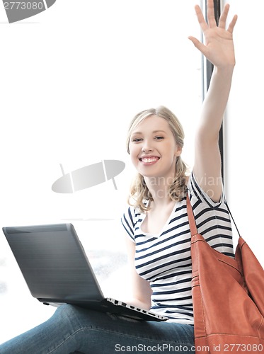 Image of happy teenage girl waving a greeting