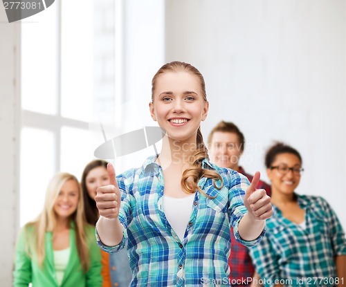 Image of young woman in casual clothes showing thumbs up