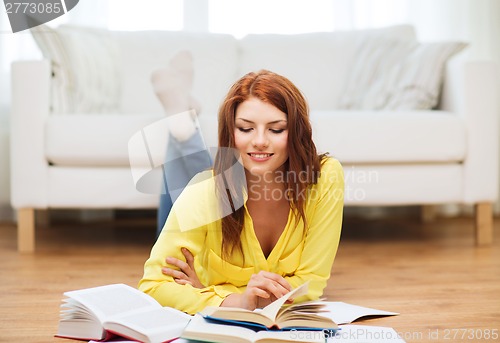 Image of smiling student girl reading books at home