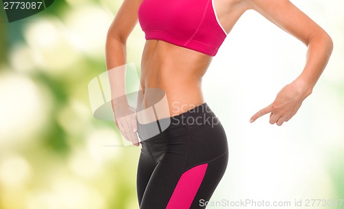 Image of close up of sporty woman pointing at her buttocks