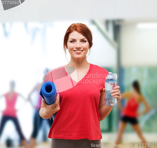 Image of smiling girl with bottle of water after exercising