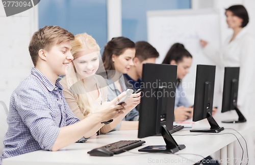 Image of students with computer monitor and smartphones