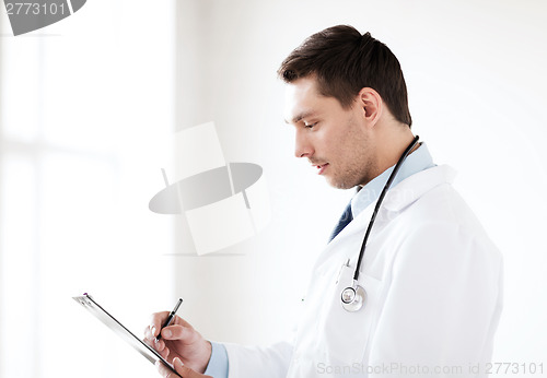 Image of male doctor with stethoscope writing prescription