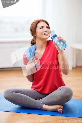 Image of smiling girl with bottle of water after exercising