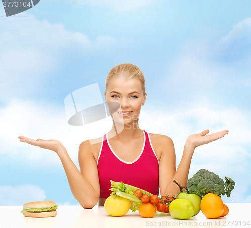 Image of smiling woman with fruits and hamburger