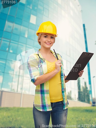 Image of smiling woman in helmet with clipboard