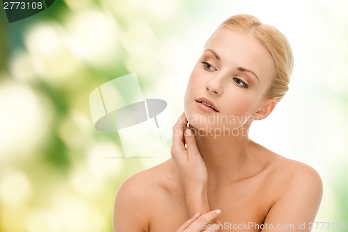 Image of beautiful woman touching her face skin