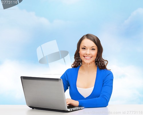 Image of smiling woman in blue clothes with laptop computer