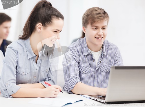 Image of students with laptop and notebooks at school