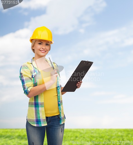 Image of smiling woman in helmet with clipboard