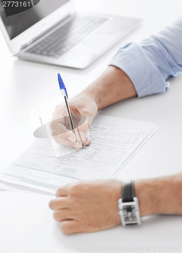 Image of man signing a contract