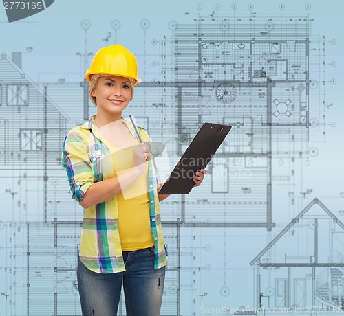 Image of smiling woman in helmet with clipboard