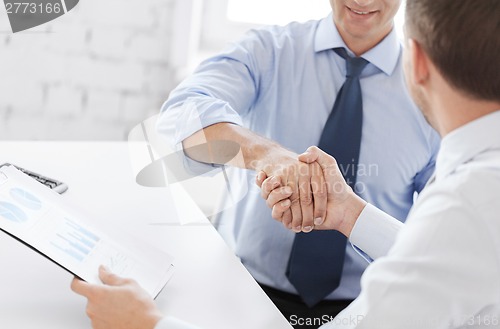 Image of businessmen shaking hands in office