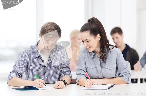 Image of two teenagers with notebooks at school