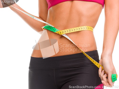 Image of close up of trained belly with measuring tape