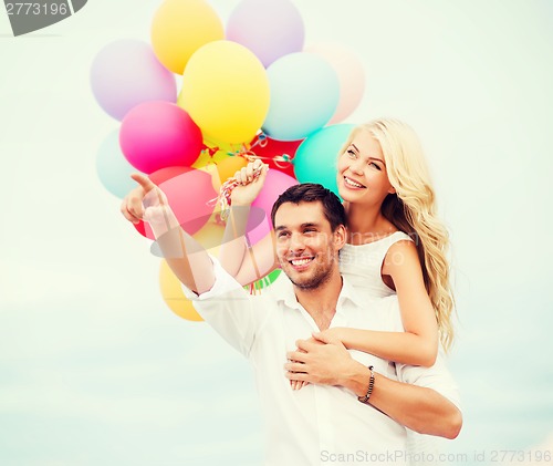 Image of couple with colorful balloons at sea side
