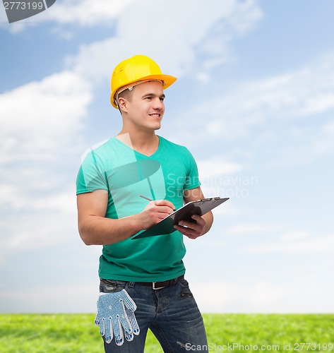 Image of smiling man in helmet with clipboard