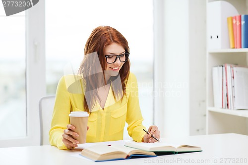 Image of smiling student girl reading books in library