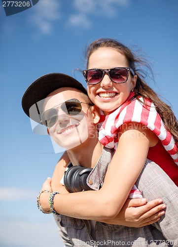 Image of smiling teenagers in sunglasses having fun outside