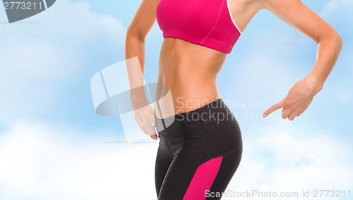 Image of close up of sporty woman pointing at her buttocks