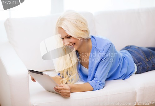 Image of smiling woman with tablet pc computer at home