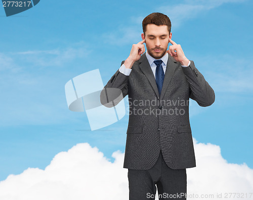 Image of annoyed businessman covering ears with his hands