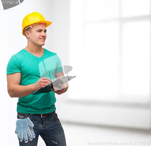 Image of smiling man in helmet with clipboard