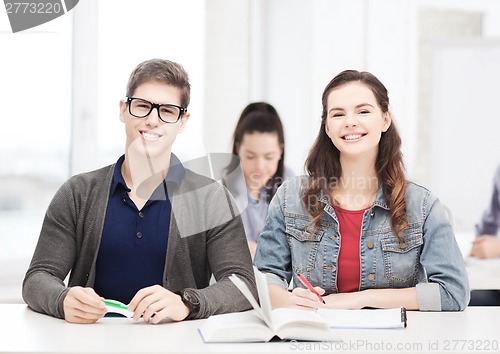 Image of two teenagers with notebooks and book at school