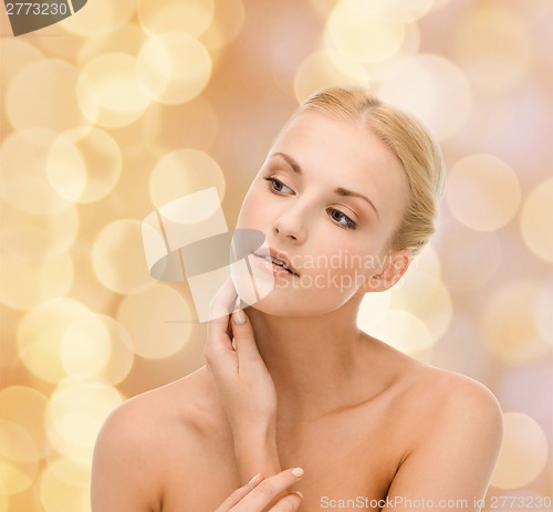 Image of beautiful woman touching her face skin