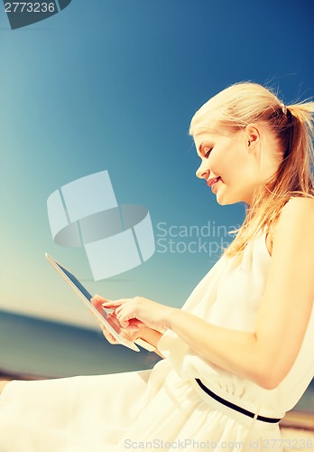 Image of beautiful woman in a dress with tablet pc