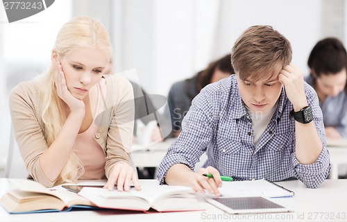 Image of tired students with tablet pc, notebooks and books