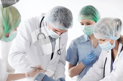 Image of young group of doctors doing operation