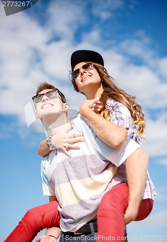 Image of smiling teenagers in sunglasses having fun outside