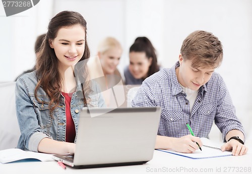 Image of students with laptop and notebooks at school