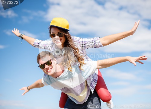 Image of smiling teenagers in sunglasses having fun outside