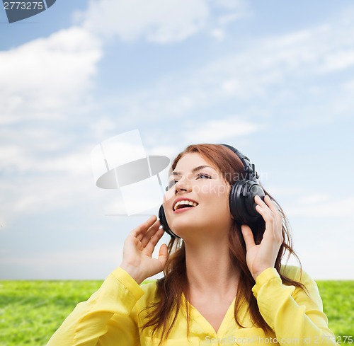 Image of smiling young girl in headphones at home