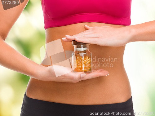 Image of close up of female hands with bottle of capsules