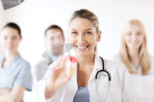 Image of female doctor with jar of capsules