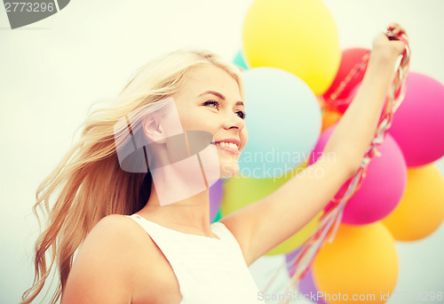 Image of woman with colorful balloons outside