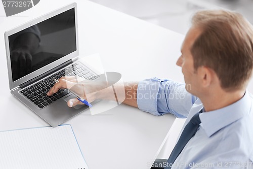 Image of smiling businessman working in office