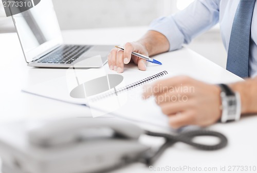 Image of businessman writing in notebook