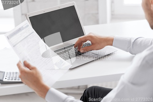 Image of miling businessman working in office